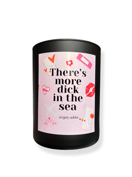 Candle with a pink label and black container on a white background