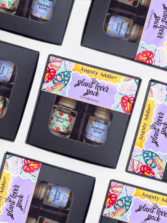 multiple identical black boxes with colorful labels, each containing a small glass jar with a plant-related label.